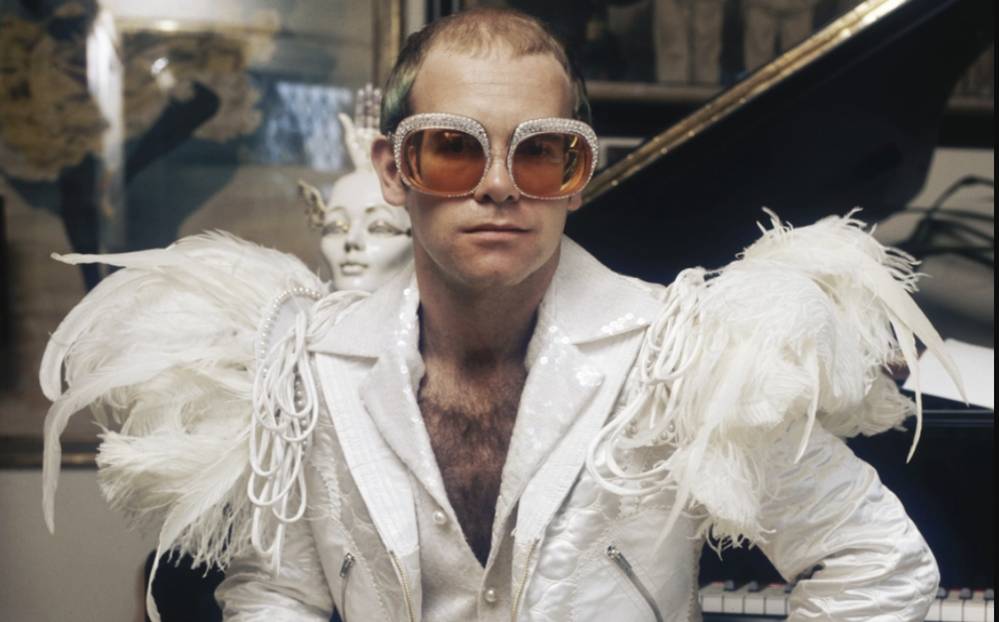 Elton John, in his younger years, the thinning hair is visible. (ctto Terry O'Neill/Hulton Archive/Getty Images from billboard.com.)